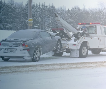 Car being towed in the snow